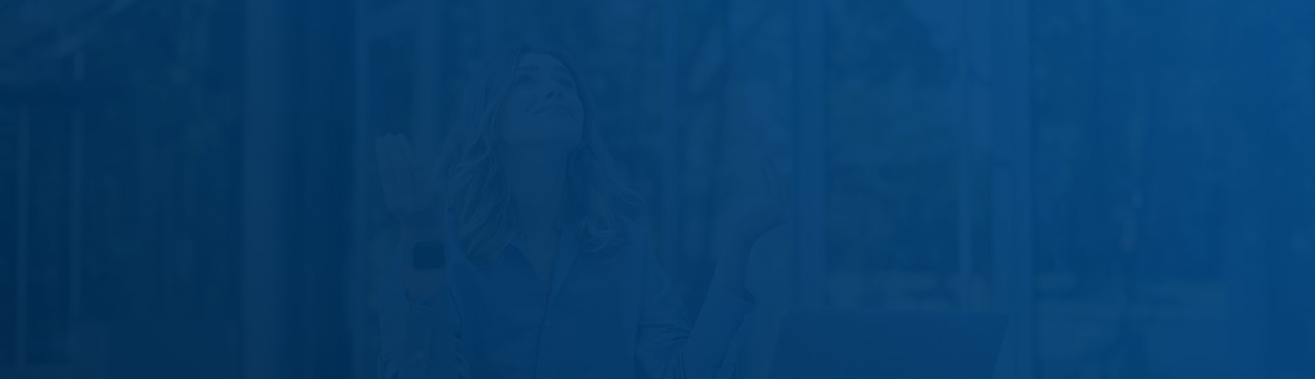 A person appears to be seated and looking up, with arms slightly raised and palms facing upward, in front of a blurred background of trees and windows. The image has a blue overlay.